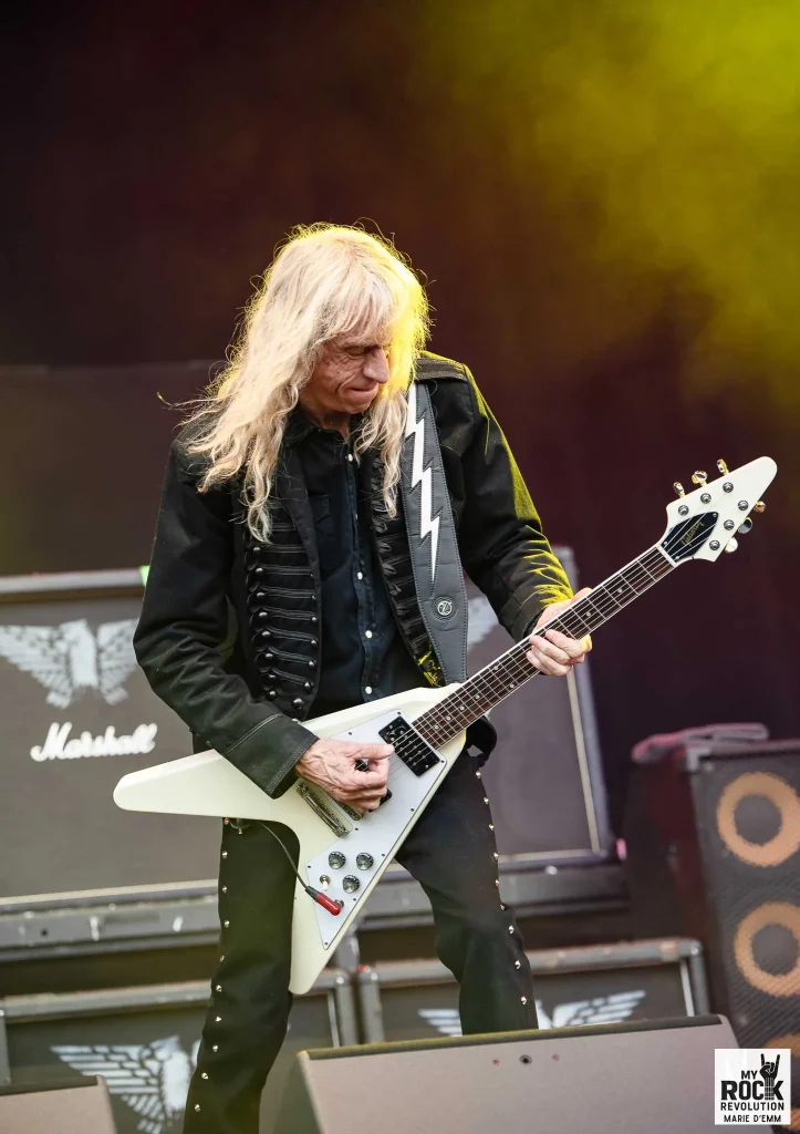Brian Tatler concentré sur sa guitare, ambiance survoltée